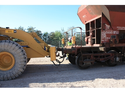 Système d'attache pour pousseur de wagons et chargeuse